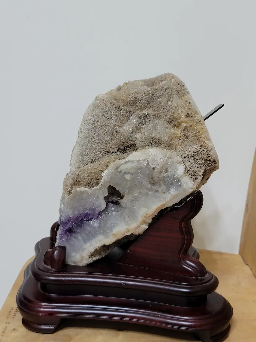 紫晶海螺左側視角與專屬木座結合展示。作為日和植所CSR專頁鎮店之寶，不僅具備地質學術研究價值，更象徵澄澈、寧靜且深邃的本心。 | Left View of White Amethyst Conch Geode with Wooden Stand. Museum-grade Uruguay Artigas Amethyst Specimen.